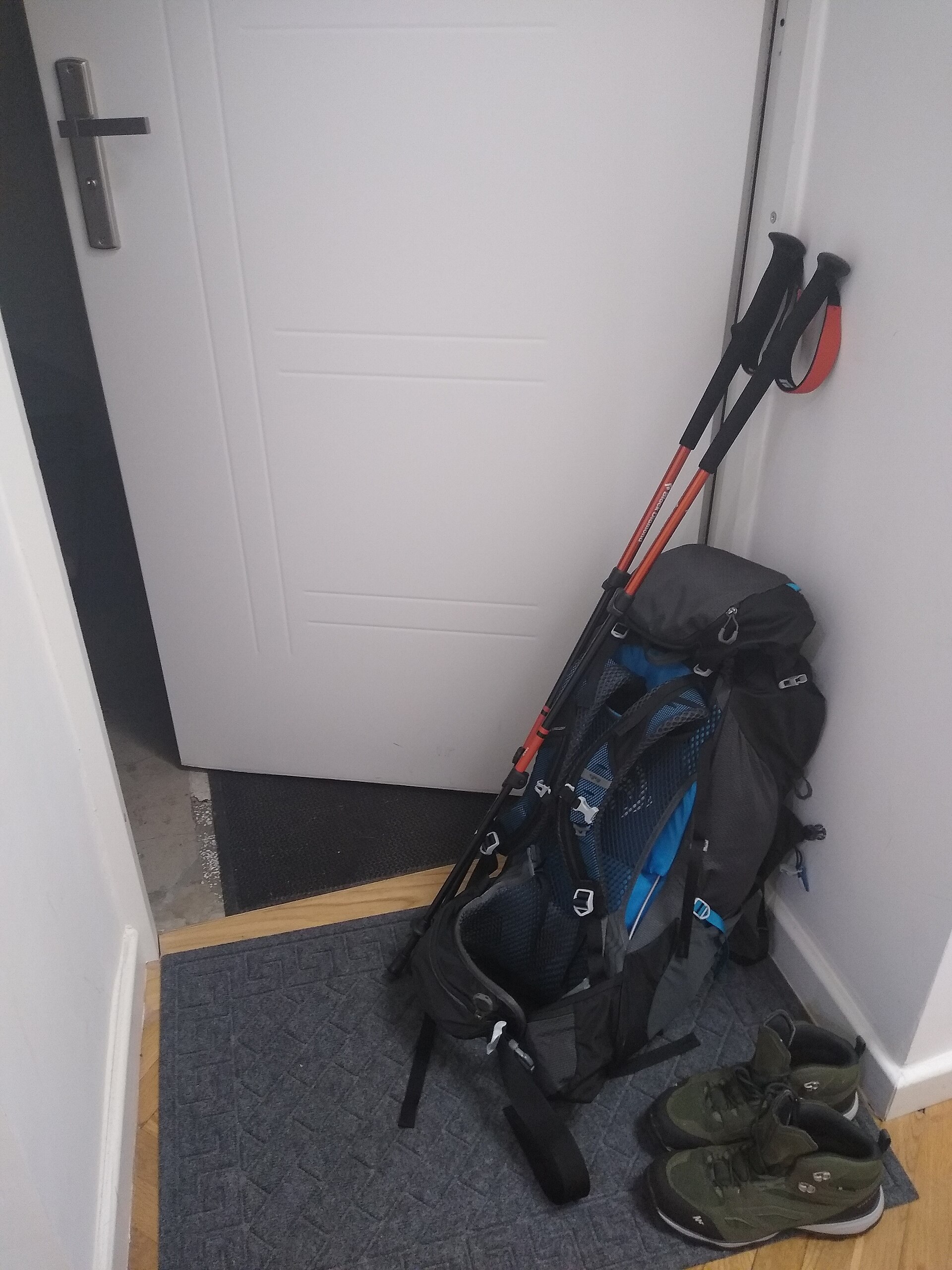 Everyday carry items including a backpack, water bottle, and notebook laid out on a desk