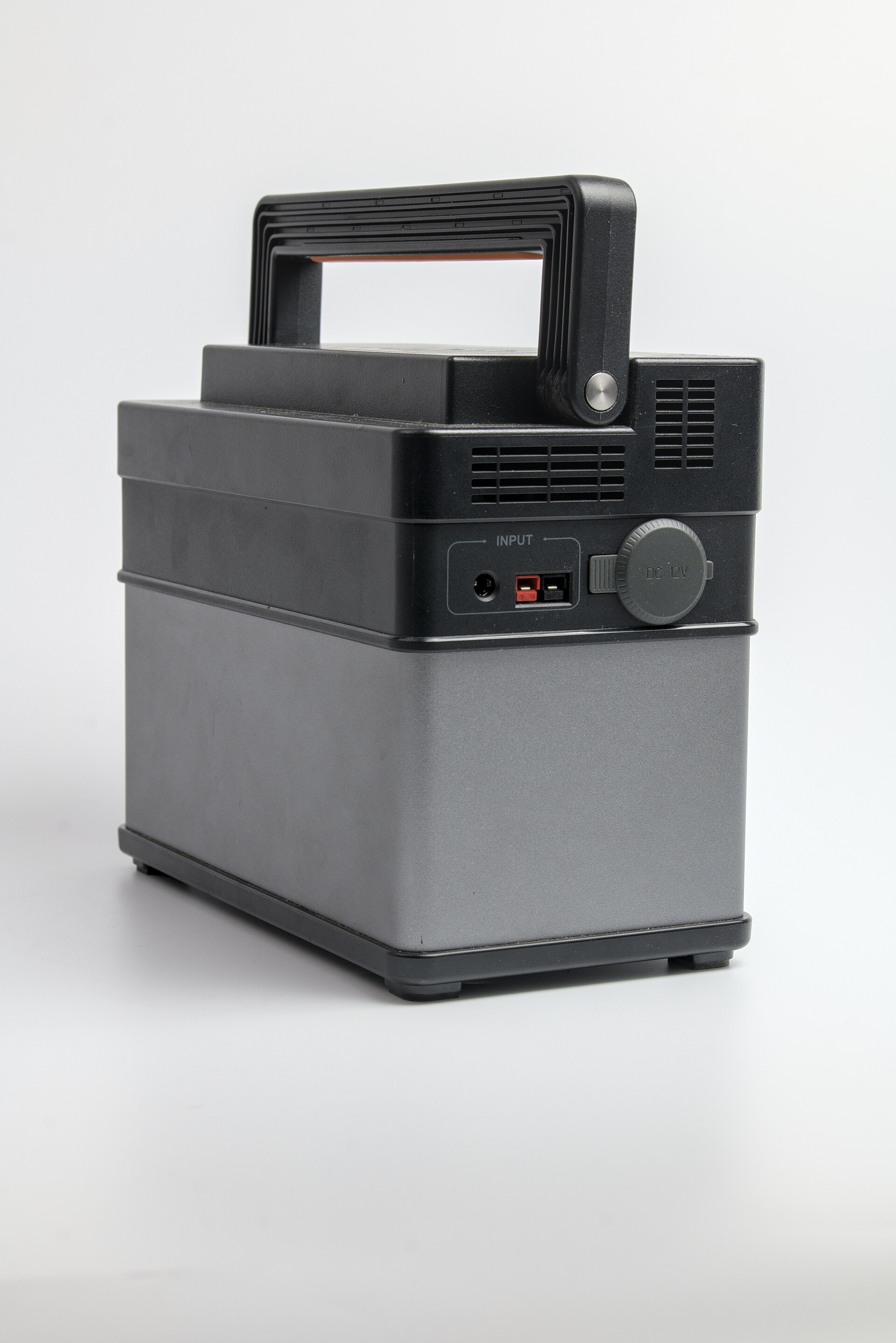 A portable power station sitting on a picnic table with a phone charging