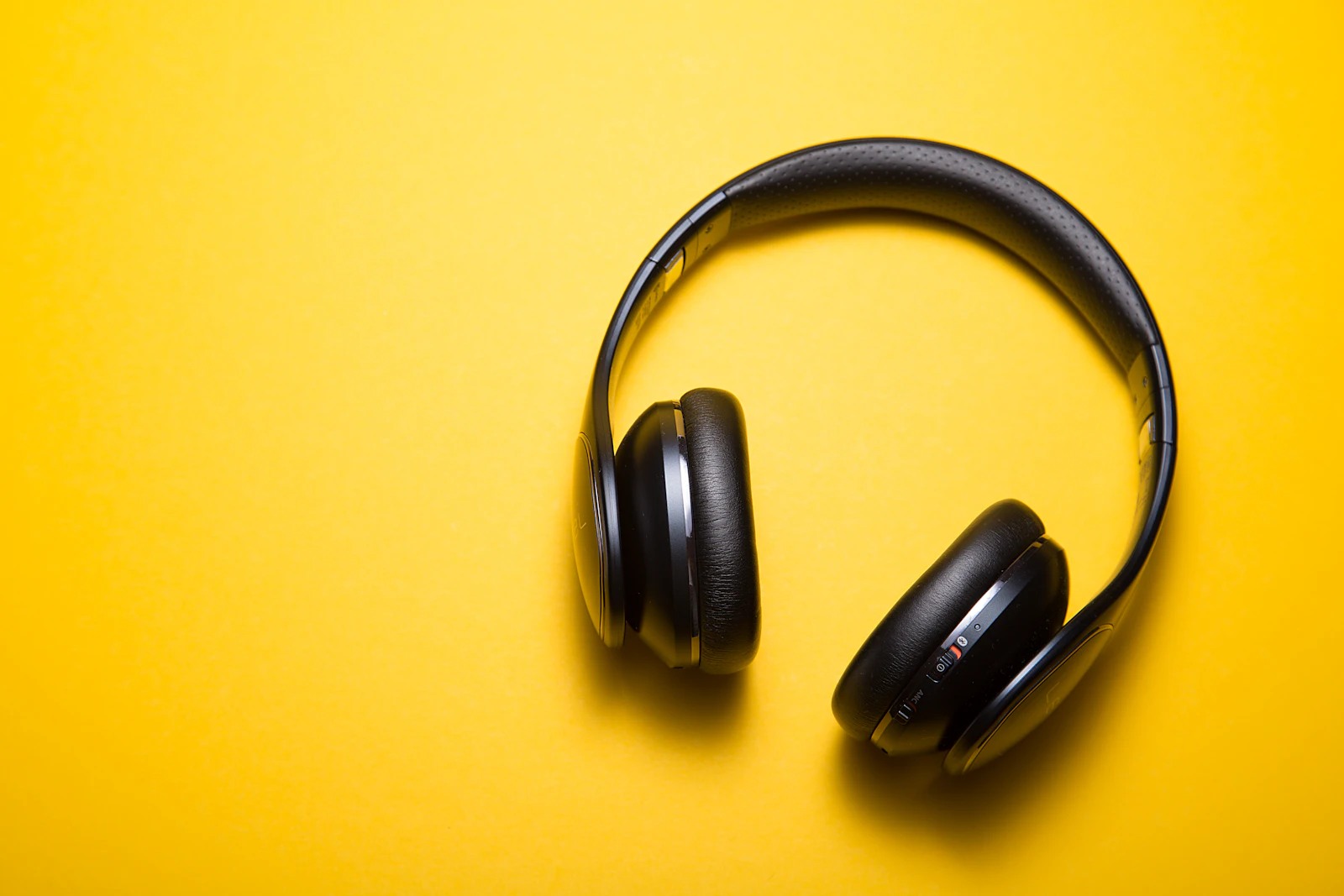 Premium over-ear headphones on a clean desk with travel passport