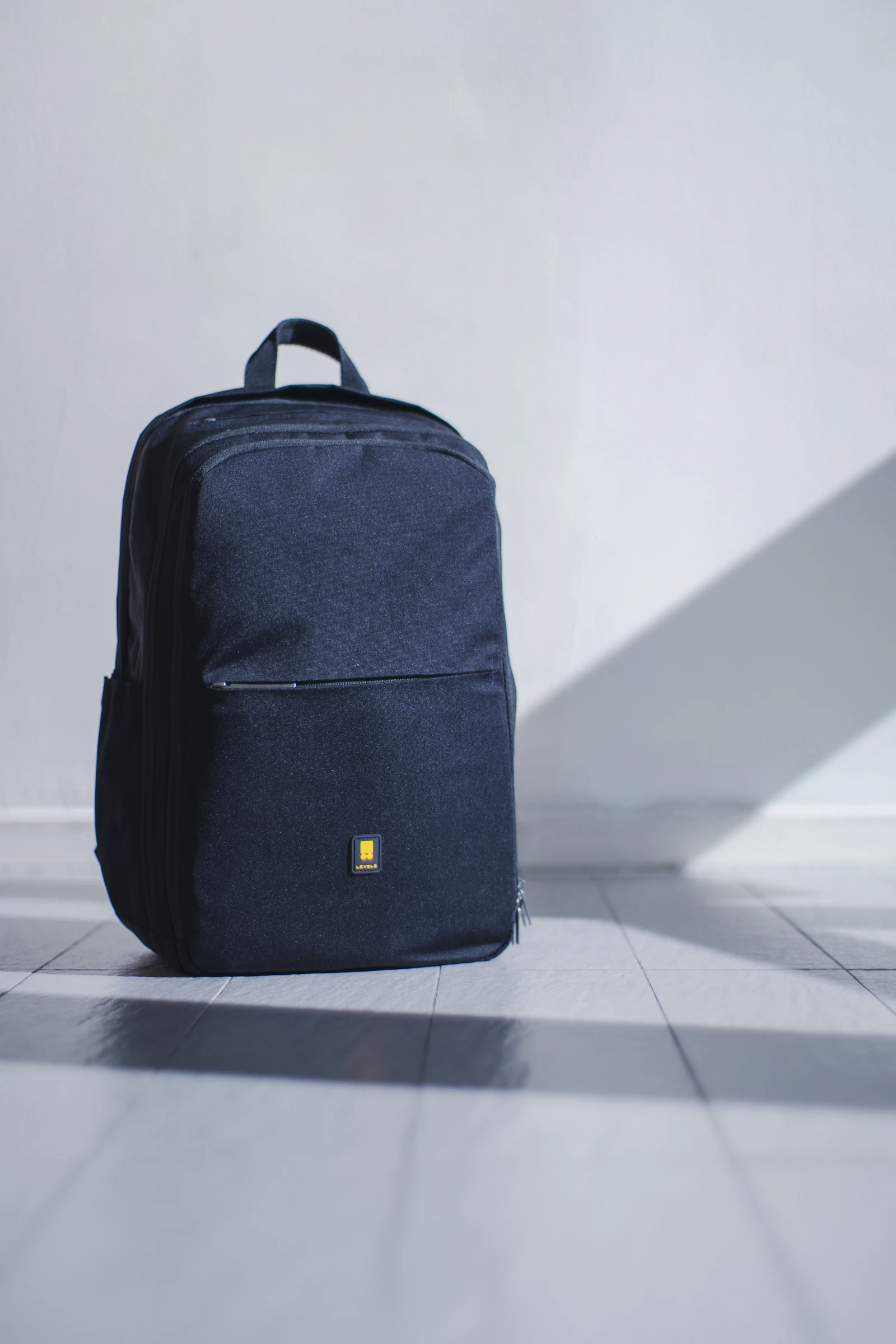 Travel backpack product shot against a minimal wall