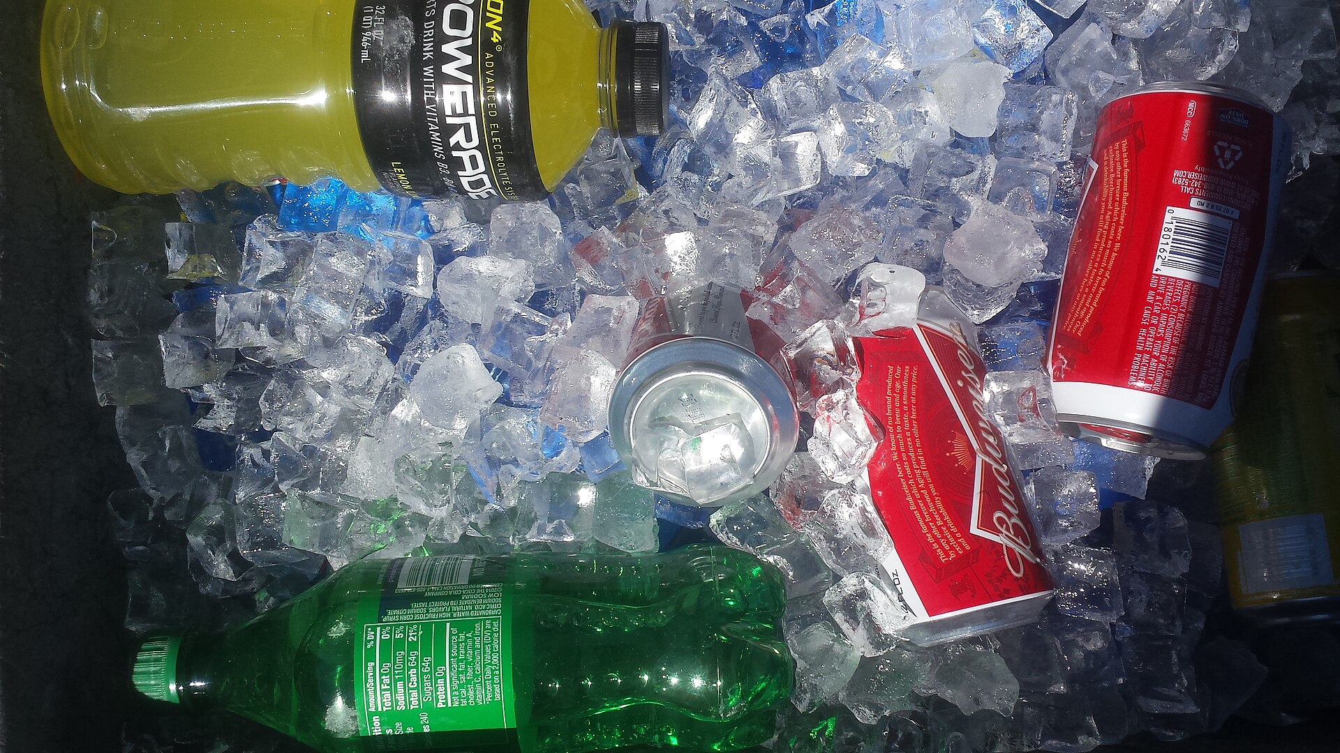 A hard-sided cooler sitting on a tailgate at a campsite